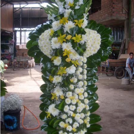 Cruz tonos amarillos moña de lado con liliums